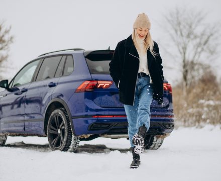 Woman in winter cloths standing by her car